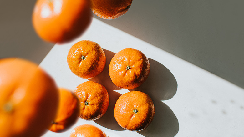 A selection of clementines, with some of them falling from above