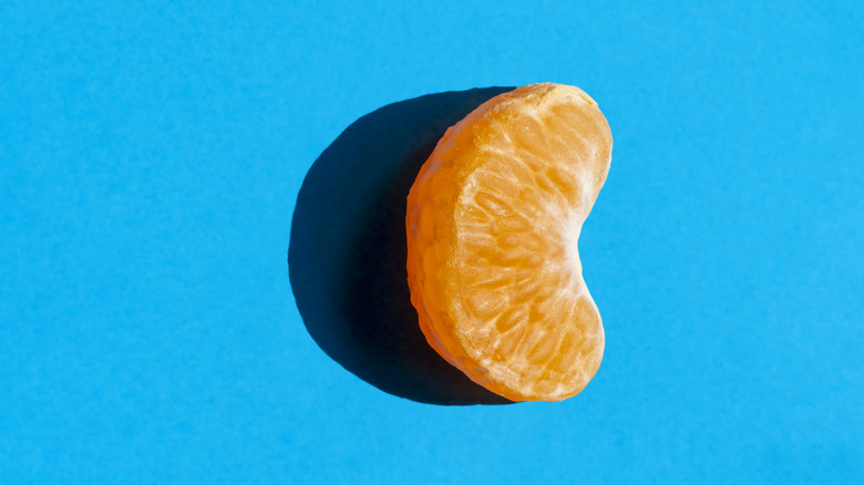 A tangerine segment on a blue background