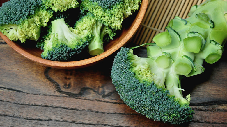 Broccoli florets in bowl, with broccoli stalk next to it