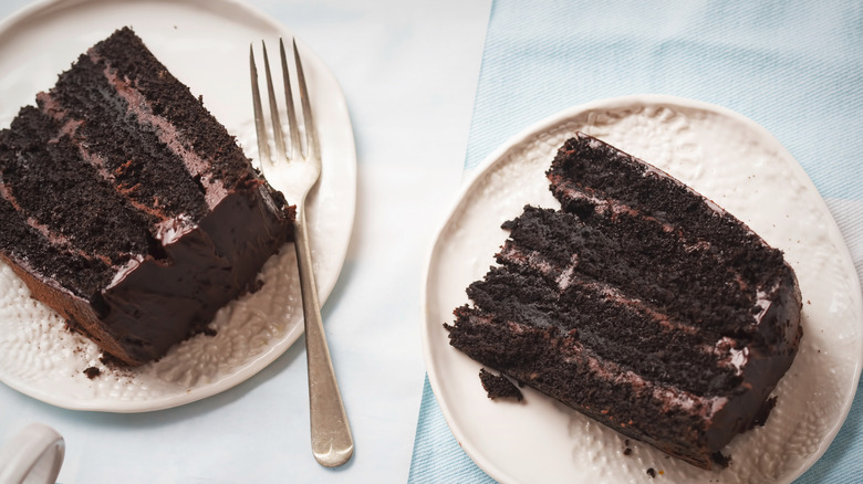 Two slices of chocolate Coca-Cola cake on plates