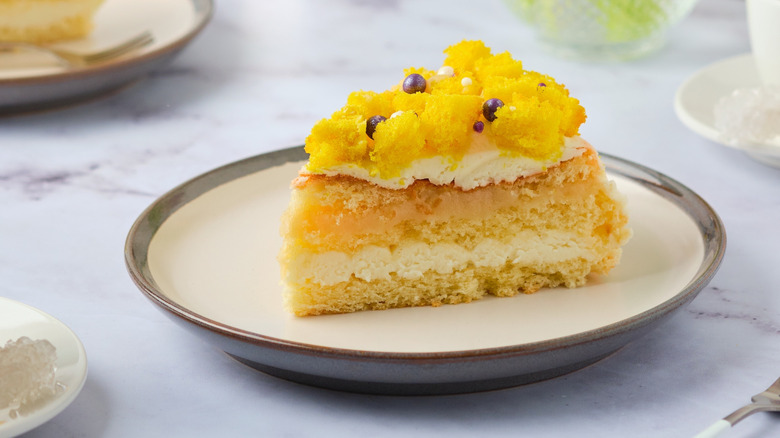 A slice of lemon cake with lemon curd and lemon cream in the middle