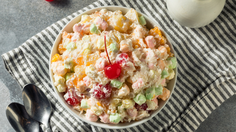 Bowl of ambrosia salad with maraschino cherry on top