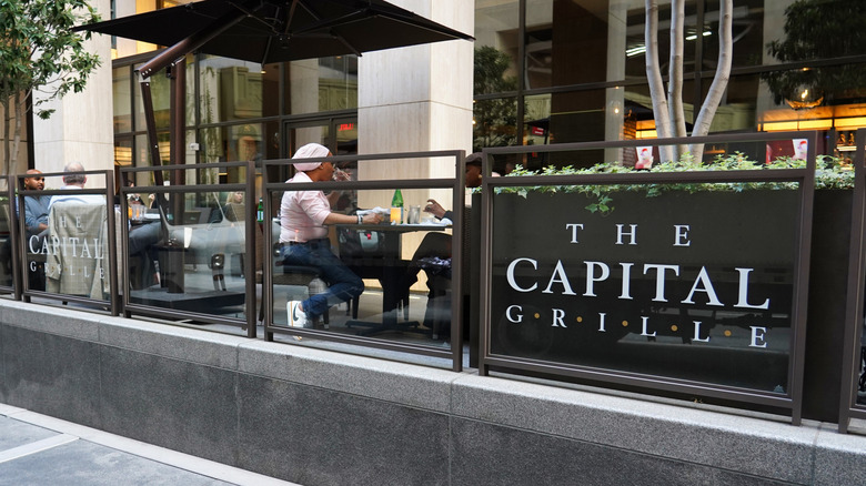 Customers eat outside a Capital Grille restaurant