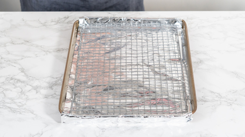 an aluminum foil-covered sheet pan with a wire rack on top.