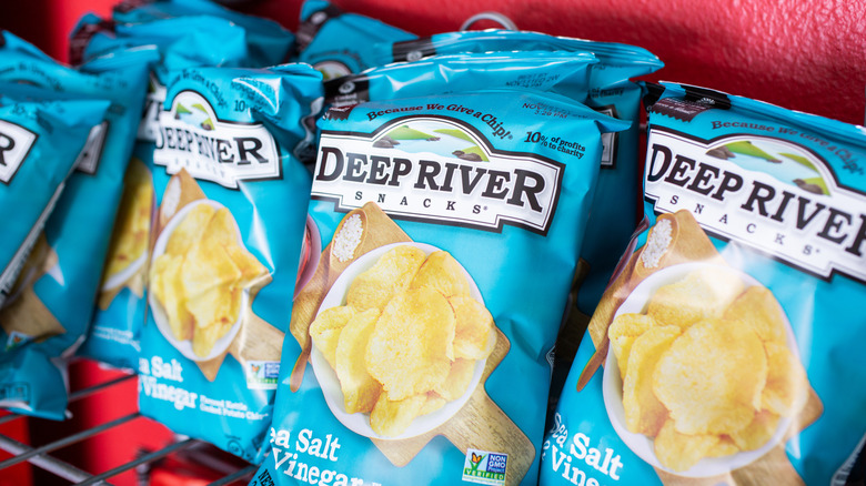 A row of Deep River Salt & Vinegar chips on a store shelf.