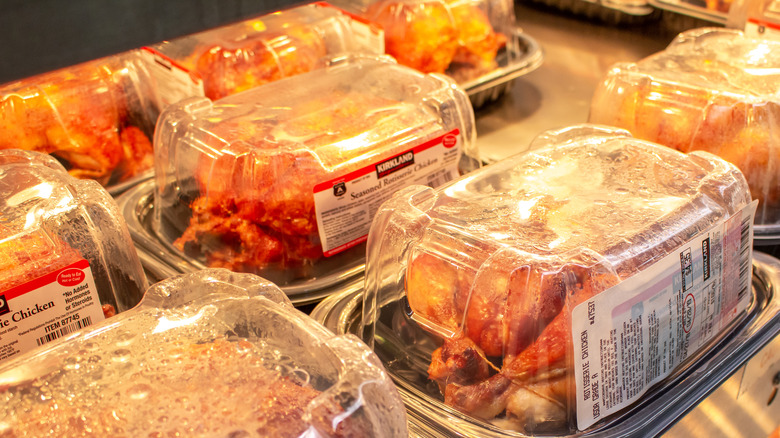 Rotisserie chickens packed in take out containers with labels on display