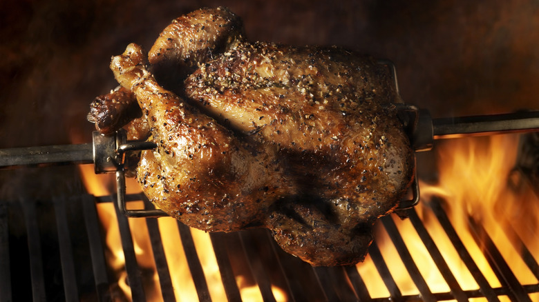 Rotisserie chicken fixed on a rod cooking in a rotisserie oven
