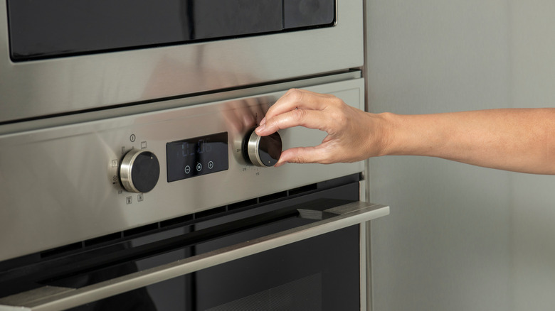 Hand adjusting knob on an oven