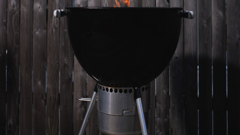 Grill in backyard, with fire coming out of it