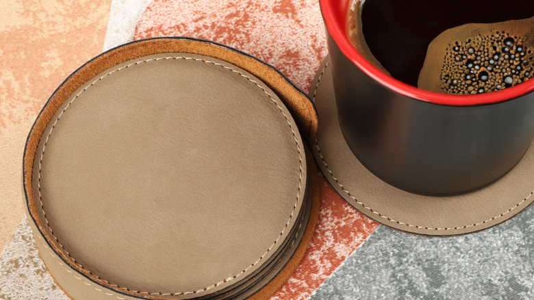 Leather coasters on a table with a cup of coffee