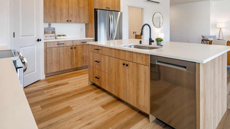 A kitchen with wooden cabinets and drawers