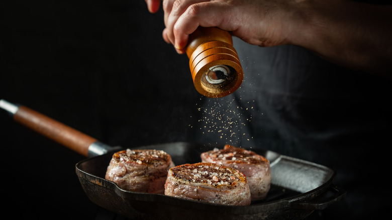 Adding pepper to steak