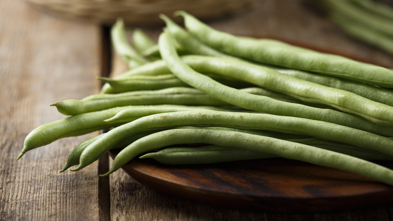 raw green beans on cutting board