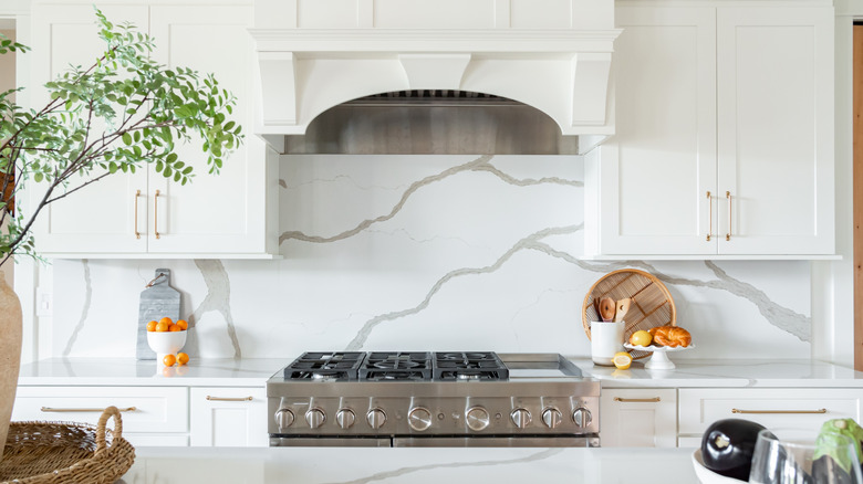Close-up of a white kitchen with stone backsplash