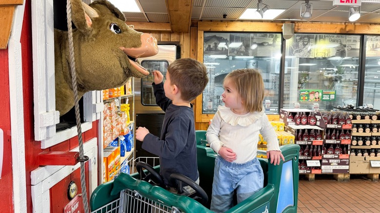 Kids playing with an animatronic cow inside Stew Leonard's