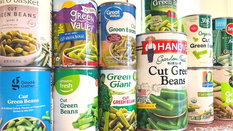 Close up image of many cans of green beans from different brands