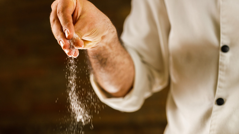 Chef adding salt