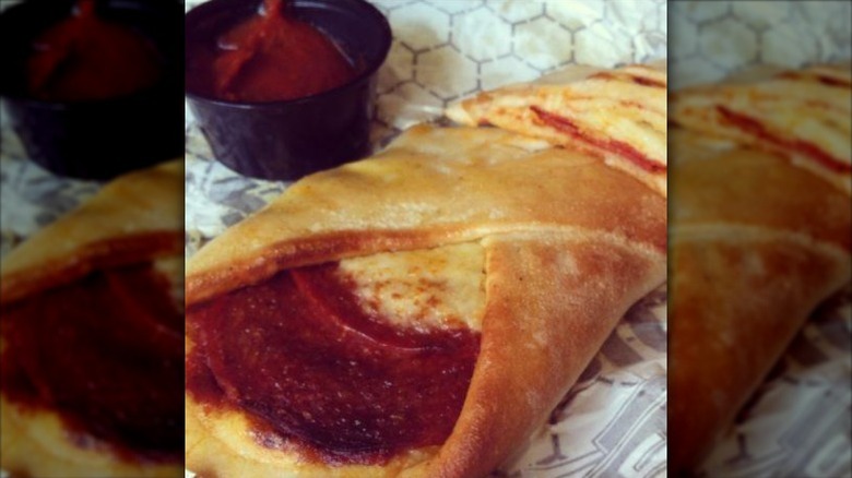 Sheetz Pepperoni Roll on wax paper, with a small dish of sauce