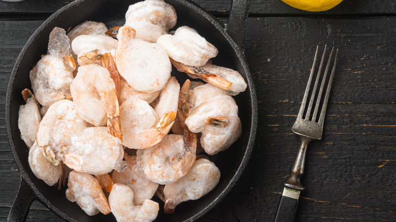 Frozen shrimp in cast iron with fork