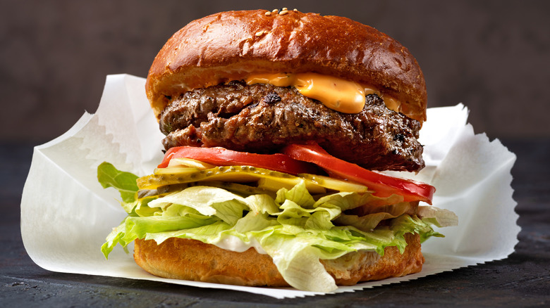 Cheeseburger with lettuce, pickles, and tomatoes