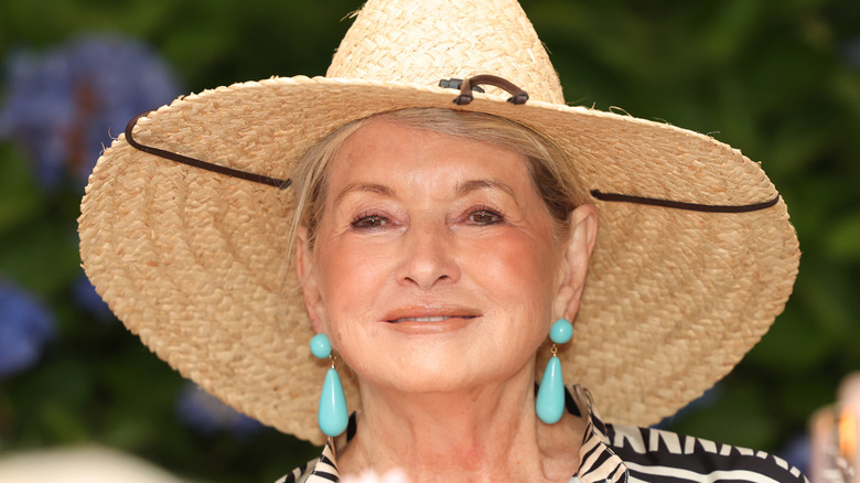 Martha Stewart wearing sun hat and blue earrings outdoors