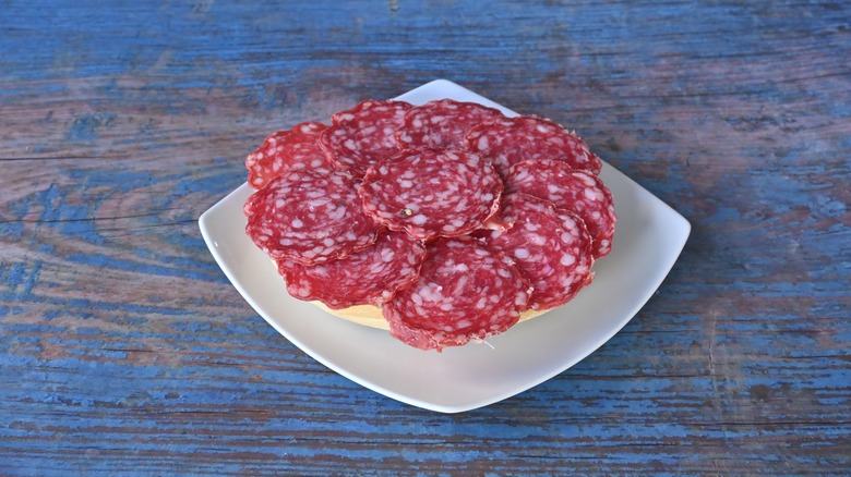 A few slices of salami with marbling and peppercorns