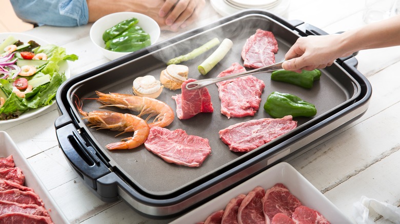 People cooking on electric griddle