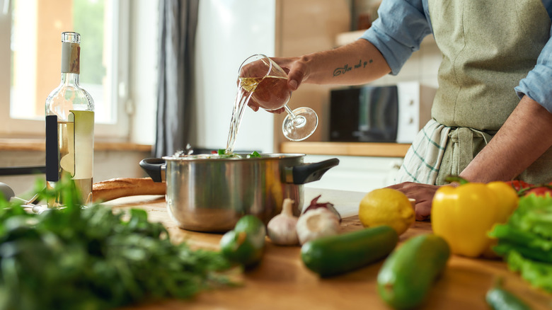 chef pouring wine into pot
