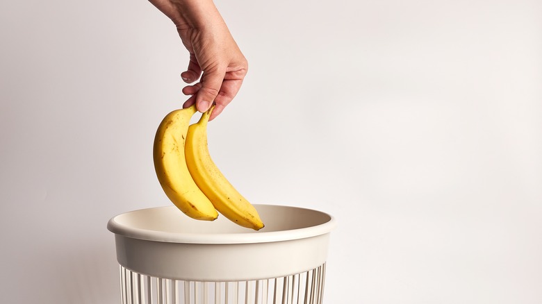 Person throwing away banana
