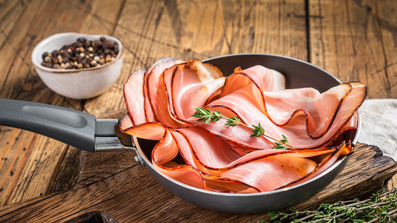 A skillet with Black Forest Ham on a wood table