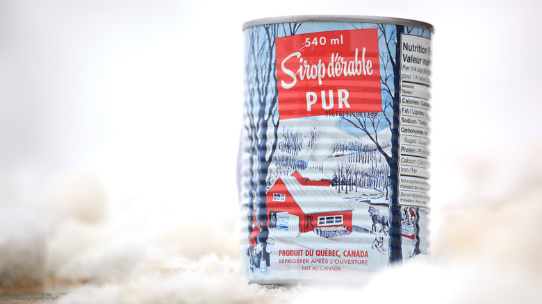 can of canadian maple syrup styled in snow