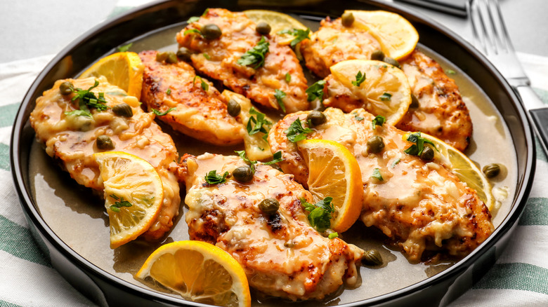 Chicken piccata on black plate
