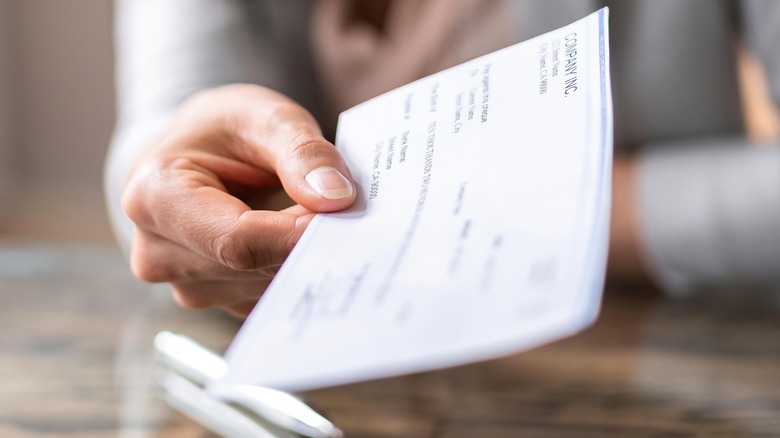Person holding paycheck