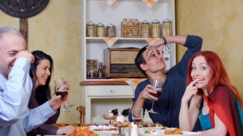 People at restaurant holding noses