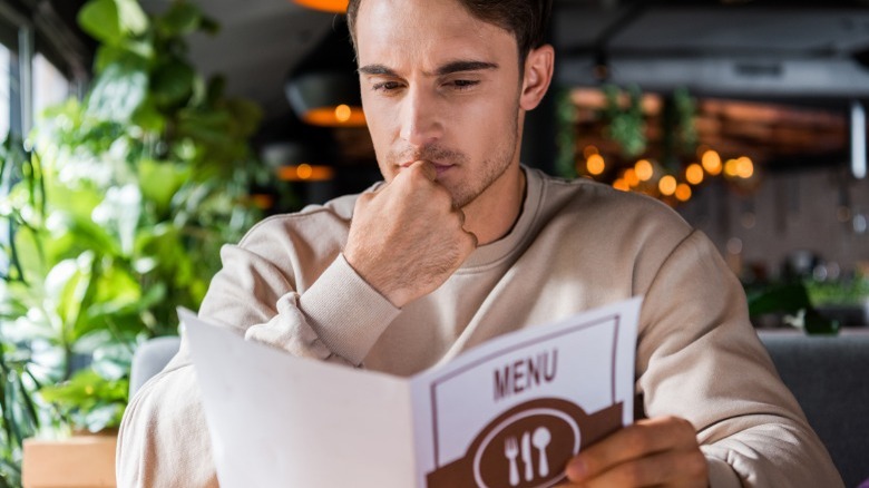 Man reading menu at restaurant