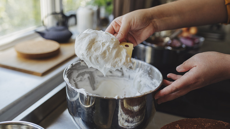 person scooping whipped heavy cream