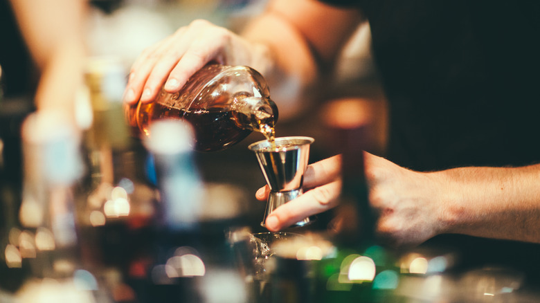 Bartender pouringa spirit into jigger