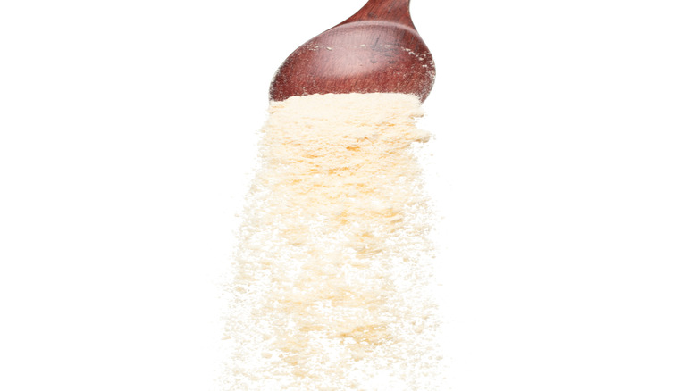 Powdered sour cream falling off of a brown spoon