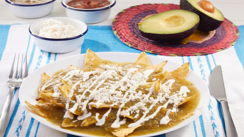 A plate of nachos topped with crema