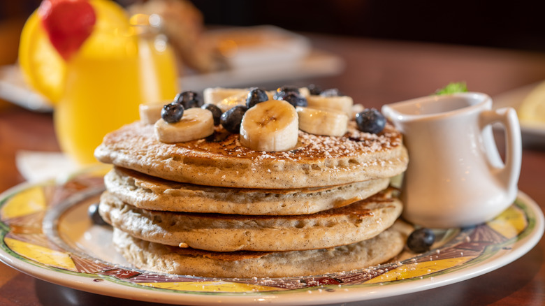 pancakes, bananas, blueberries, orange juice, white ramekin, sugar