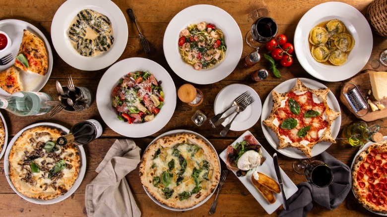 Plates of Italian food on wooden table