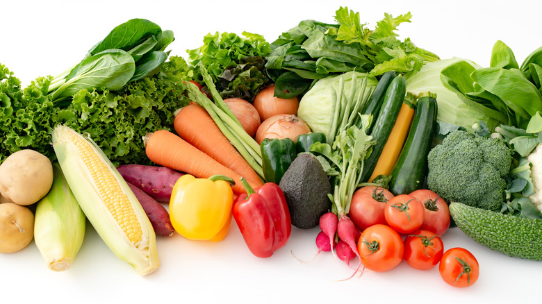 Various vegetables grouped together on a white background