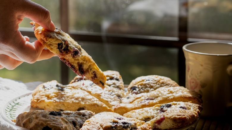 Person grabbing freshly baked scone