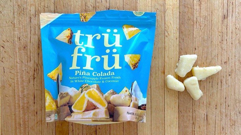 Package and pieces of Nature's Pineapples Piña Colada Hyper-Chilled in White Chocolate and Coconut