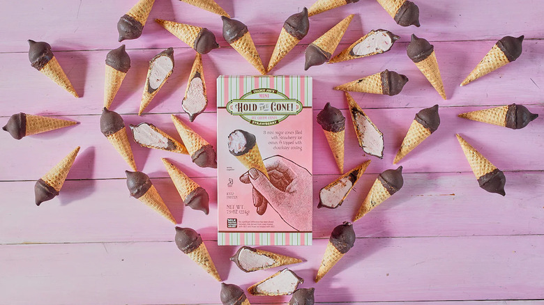 chocolate covered strawberry ice cream cones on pink background surrounding box from trader joe's