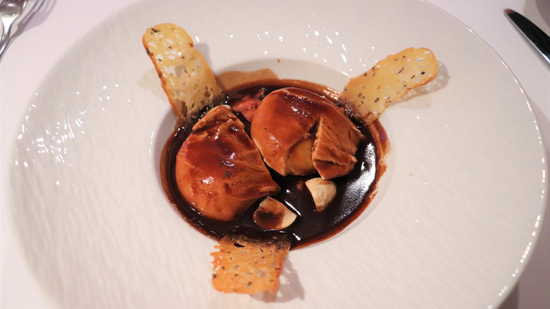 Egg poached in red wine on white plate