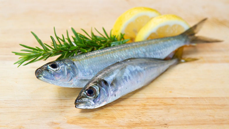Two sardines on wooden board