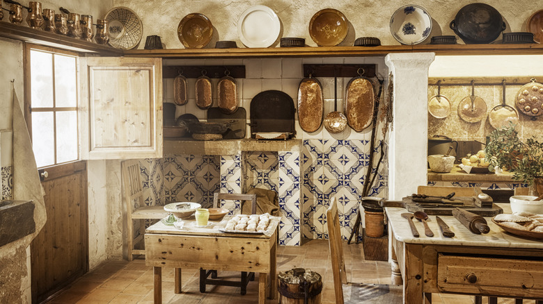 An old-fashioned kitchen with a freestanding table and chair in the center
