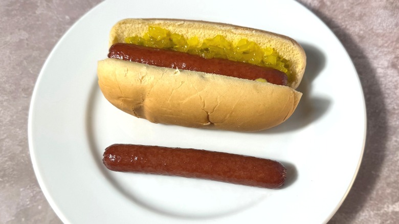 Rich brown deep-fried hot dogs, plain and in a bun with relish and mustard.