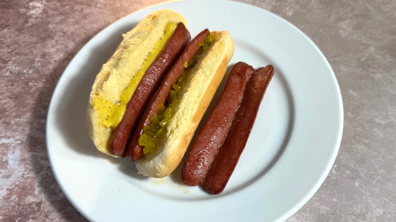 Butterflied hot dogs, plain and in a bun with relish and mustard.